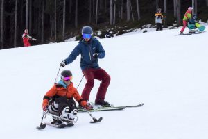 Skifahren im Sitzski mit Krückenski